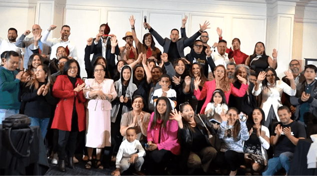 Grupo numeroso y diverso de miembros de la comunidad Transformando Comunidades celebrando juntos