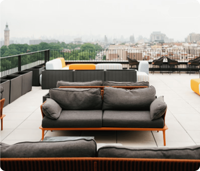 Terraza del venue con sofás y vista al skyline.