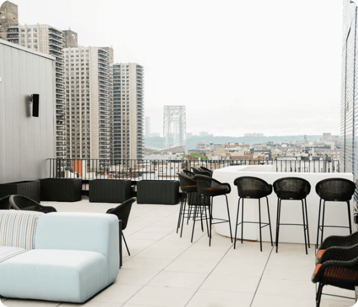 Zona lounge del venue con mesas altas y vista urbana.